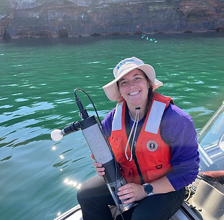 Summer staff holding a sonde unit on Lake Superior