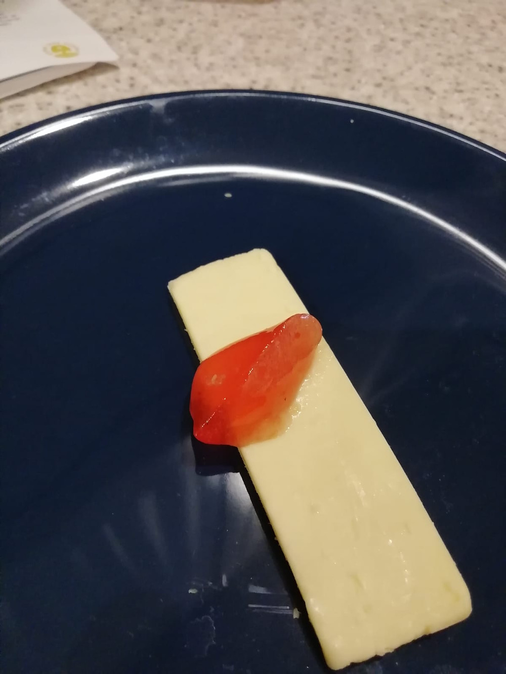 The finished orange coloured rowan jelly on a slice of cheese