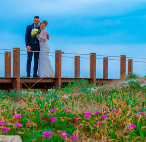 Sposi su passerella in legno con fiori