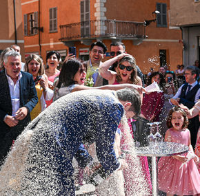 Coppia di sposi coperta di riso dagli invitati