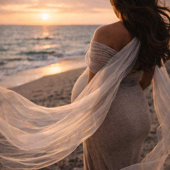 Donna incinta sulla spiaggia al tramonto