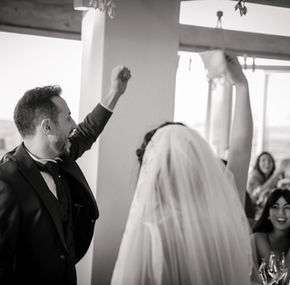 Sposi che festeggiano con le braccia alzate