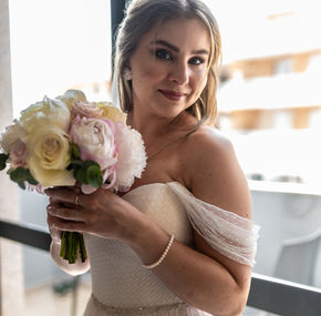 Sposa in abito bianco con bouquet.