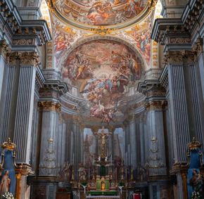 Interno di chiesa barocca con affreschi e altare.