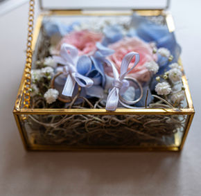 Anelli nuziali in scatola di vetro con fiori rosa e blu