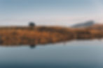 Land-Rover-in-the-Scottish-Highlands-reflecting-in-the-water-on-side-of-a-Loch
