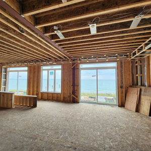 Unfinished room with exposed beams and ocean view.