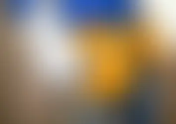 A handyman wearing a tool belt filled with various tools, holding pliers and a hammer.