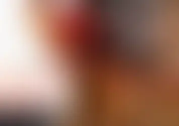 Handyman wearing tool belt with tools and holding red hard hat.