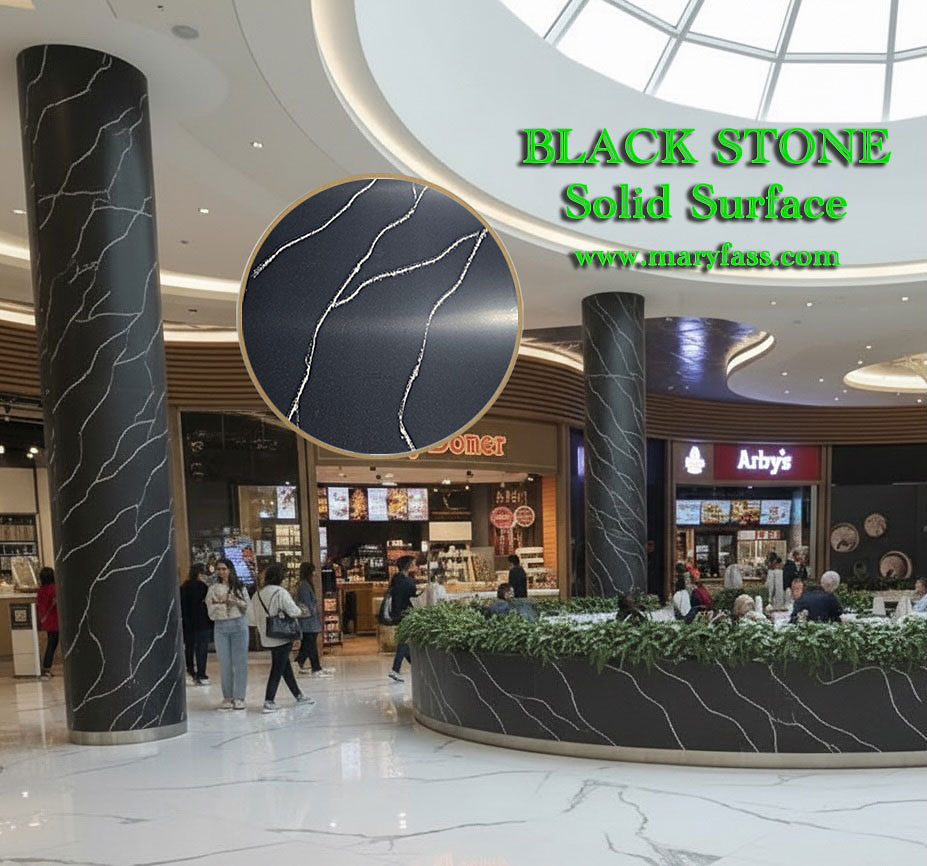 A busy commercial mall interior displaying massive pillars and a curved customer bar counter finished in matching elegant black marble-look solid surface.