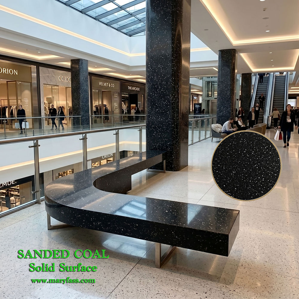A sweeping, minimalist glossy black speckled solid surface bench spanning across a brightly lit, polished marble flooring mall atrium.