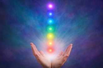 Hands emitting colorful chakra energy beams with a vibrant, mystical background.