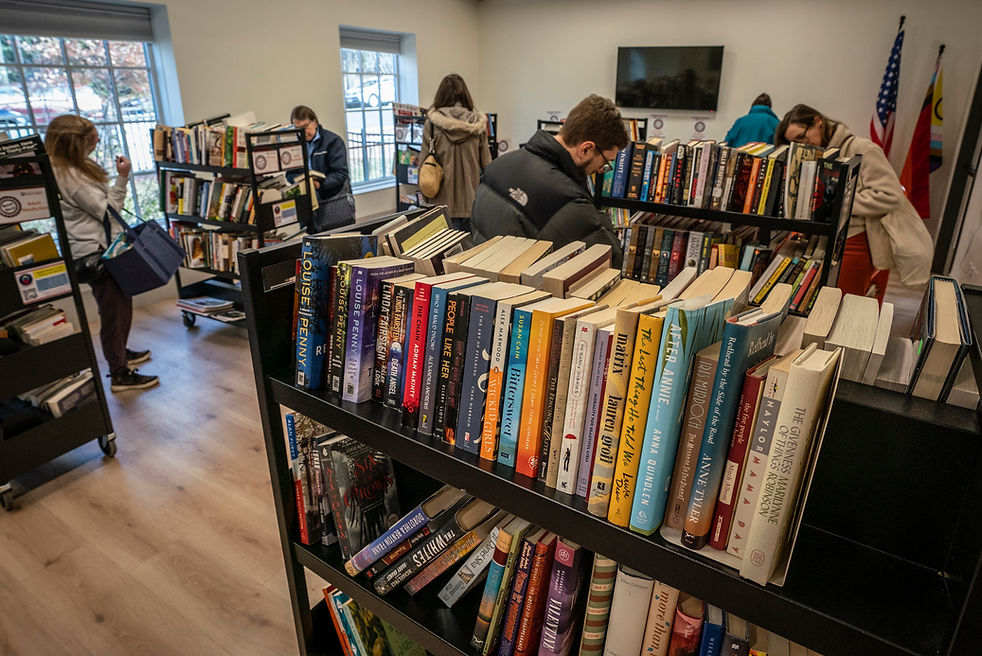 this image shows shelves of books being examined during a book sale.