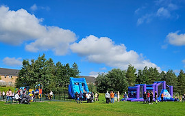 Photograph of playing fields on a sunny day with activities and inflatables