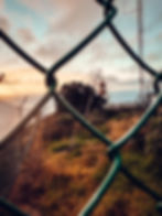 Sunset at Ponta do Pargo Lighthouse viewpoint, Madeira Island, with the lighthouse standing tall on the cliff edge and the fiery red and orange sky reflecting on the Atlantic Ocean