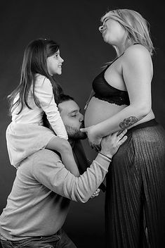 ritratto premaman, uomo bacia la pancia della sua donna