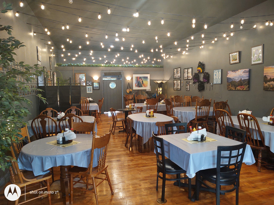 The main dining room is a comfortably large room with many 4-6 person tables. The available restrooms are also visible at the back of the room. 