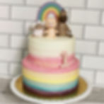2 tier rainbow birthday cake with animal toppers and rainbow