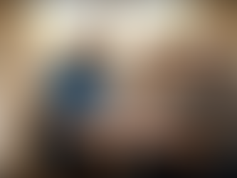 A compassionate in-home caregiver from Freudenthal Home-Based Healthcare sitting with an elderly father and his adult daughter at a kitchen table reviewing a care plan for Medicaid in-home care services, natural sunlight through large windows, warm welcoming home environment, smiling and supportive conversation, paperwork on the table, plants in background, authentic lifestyle photography, midwest home setting, professional documentary style