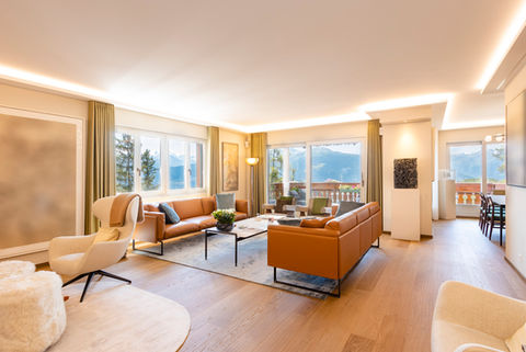 Les clients avaient exprimé leur souhait de métamorphoser complètement l'atmosphère de leur appartement, tout en repensant entièrement l'aménagement de chaque pièce. Ils ne désiraient plus un intérieur style montagne. Ainsi, nous avons entrepris une démarche radicale en déshabillant totalement les espaces, afin de repartir de zéro et concrétiser ce projet ambitieux.
L'aspect central pour eux résidait dans l'agrandissement de la zone de réception, conjugué à la nécessité de cloisonner la cuisine. Cette dernière a été isolée grâce à l'introduction de deux portes coulissantes Rimadesio, à la fois fonctionnelles et esthétiquement remarquables, séparant avec finesse l'espace de vie de la cuisine.
Une attention minutieuse a été accordée à la sélection des teintes murales, destinées à se fondre harmonieusement avec le mobilier tout en insufflant douceur et modernité au projet global. 
Notre intervention s'est également concentrée sur l'aspect électrique, visant à instaurer un éclairage optimal tout au long de la journée, en accord avec les besoins spécifiques. Les espaces de vie ainsi que les chambres ont été dotés de corniches éclairées indirectement, créant ainsi une ambiance envoûtante tout en préservant la belle hauteur sous plafond. Quant aux autres pièces, l'intégration de rails LED encastrés a été privilégiée, apportant une dynamique lumineuse. 
