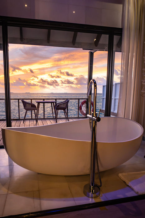 The bathtub in the overwater villa, facing the sunset