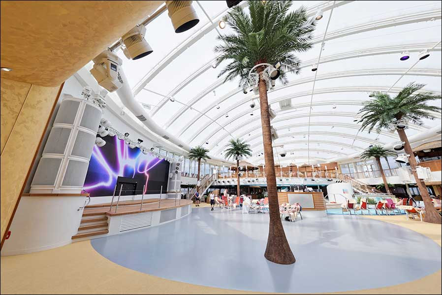 The Beach Club on AIDanova with palm trees and stage area.