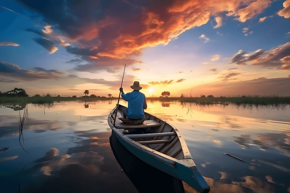Person in a canoe paddles across a calm marsh at sunset, with glowing orange clouds and mirrored water creating a peaceful scene.