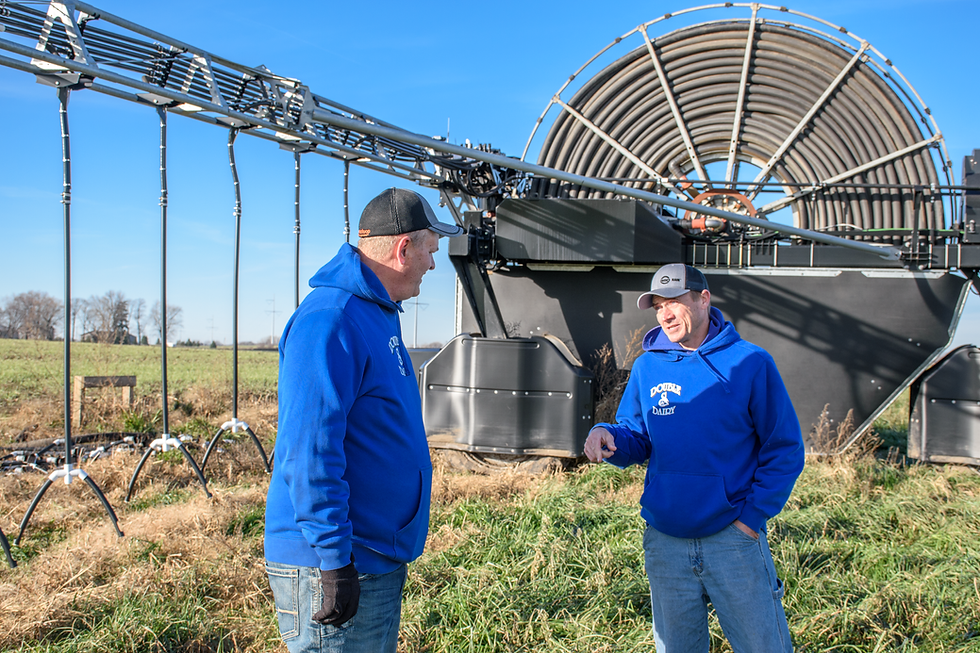 Two farmers discuss dairy conservation near advanced equipment