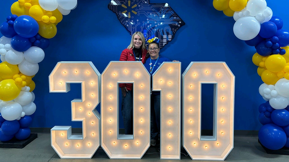 3010 marquee numbers under a blue and yellow balloon arch