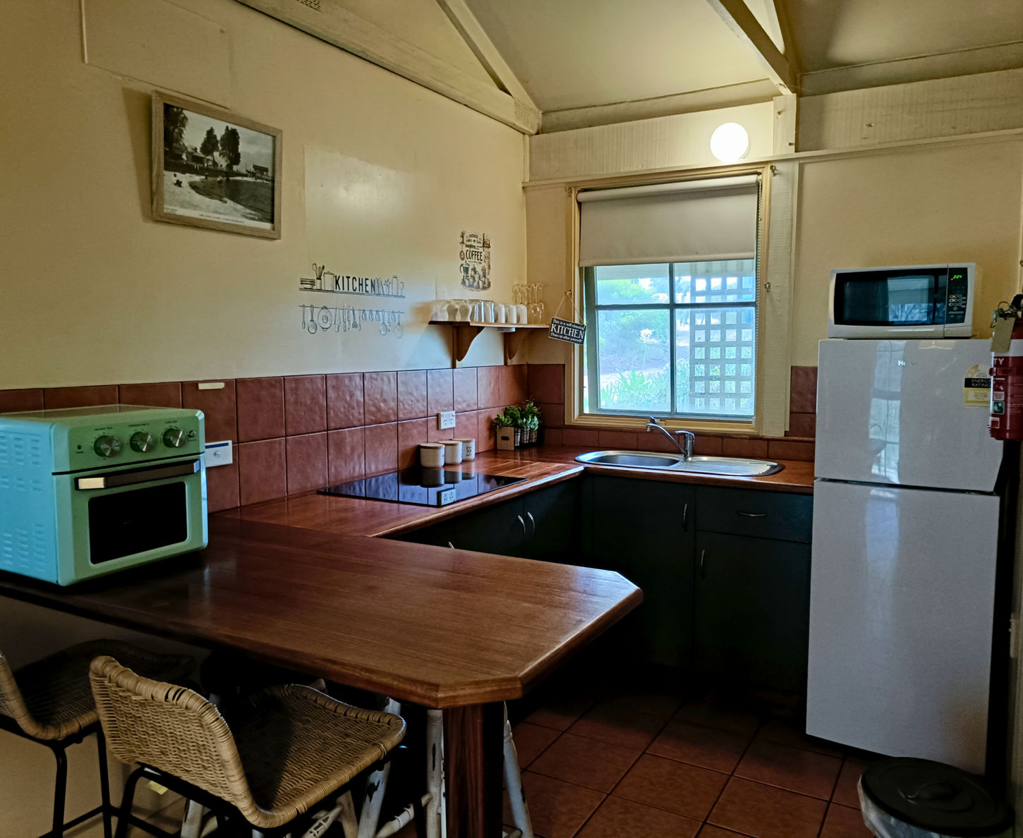 Small cottage kitchen with wooden counters and white fridge