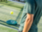 Padel Club player bouncing a ball.