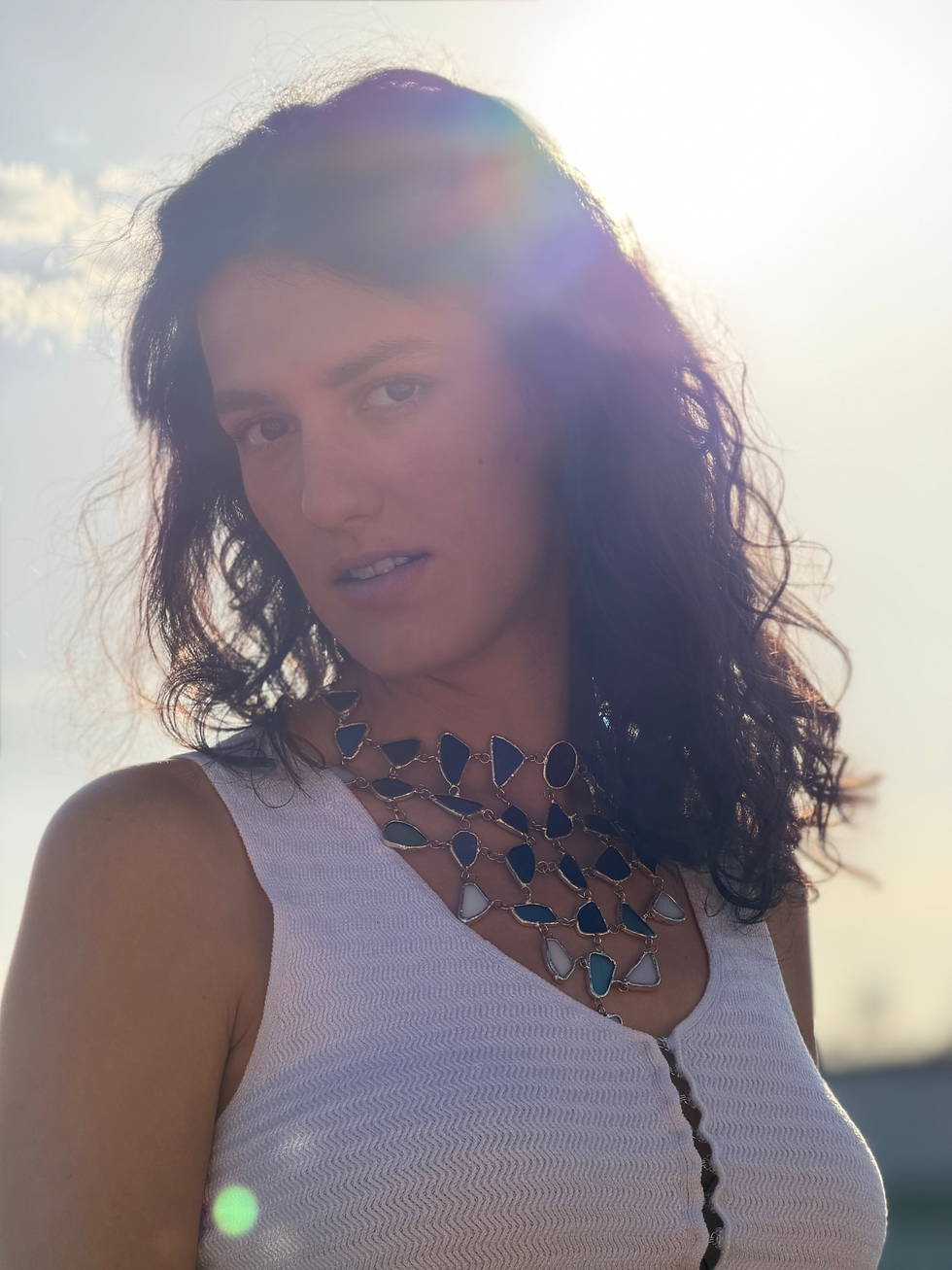 Thumbnail: Plano de cerca chica con collar bonito puesto de piedras de vidrio en diferentes tonos de azul y blanco estilo marino