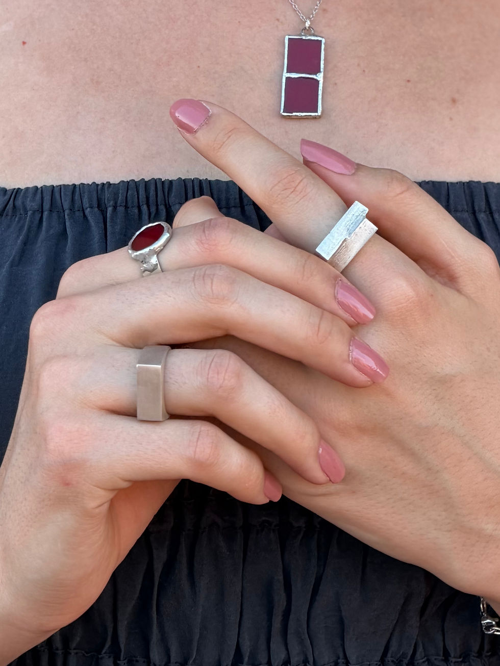 Miniatura: Manos de mujer con anillo plateado y vidrio rojo estilo Tiffany