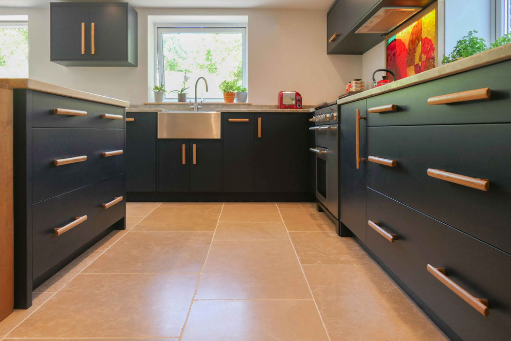 a handcarfted, bespoke modern kitchen design with sleek, smooth cabinetry and rustic oak handles