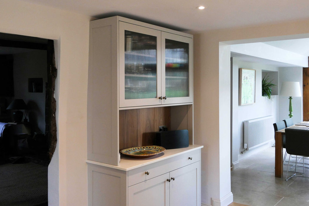 a hancrafted, bepsoke modern kitchen with a smooth, framless design with shaker inspired doors and drawers, paired with satin brass handles and a bespoke walnut kitchen island