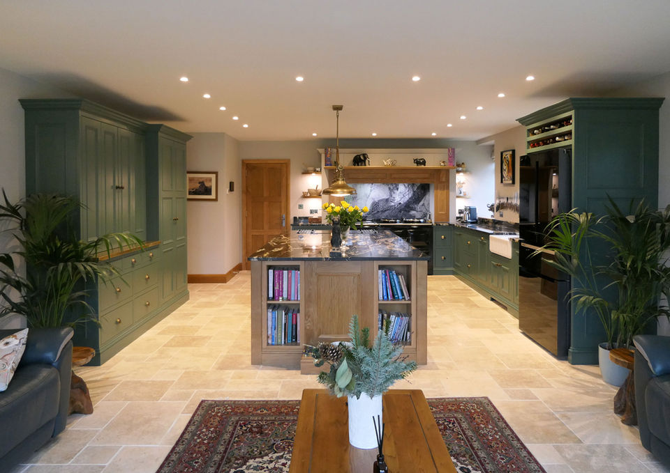 a handcrafted bespoke shaker kitchen with soft green perimeter cabinetry, a stunning oak kitchen island, a beautiful black worktop with gold details, a custom brass worktop and many more bespoke kitchen details