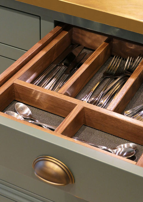a handcrafted bespoke shaker kitchen with soft green perimeter cabinetry, a stunning oak kitchen island, a beautiful black worktop with gold details, a custom brass worktop and many more bespoke kitchen details