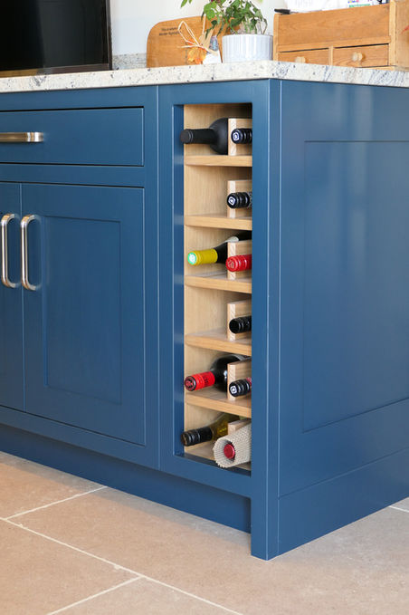 a handcrafted custom shaker kitchen featuring dark blue painted cabinetry, satin nickel handles, a grey granite worktop and warm rustic oak detailing throughout