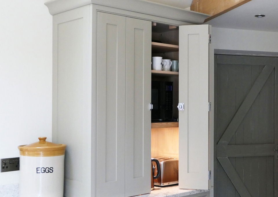 A handmade, bespoke shaker kitchen with neutral cabinetry and an eye-catching navy and red dresser. Paired with satin nickel handles, bespoke oak features and rustic details.
