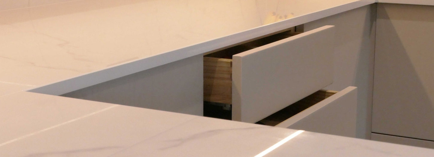 a handcrafted bespoke modern kitchen with sleek white cabinetry and our innovative push-to-open cbainetry design