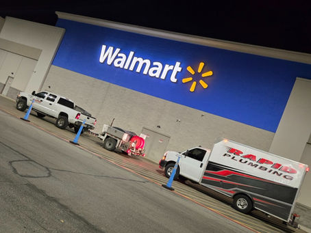 Rapid Plumbing trucks and hydro jetting equipment outside Walmart at night for commercial drain descaling service