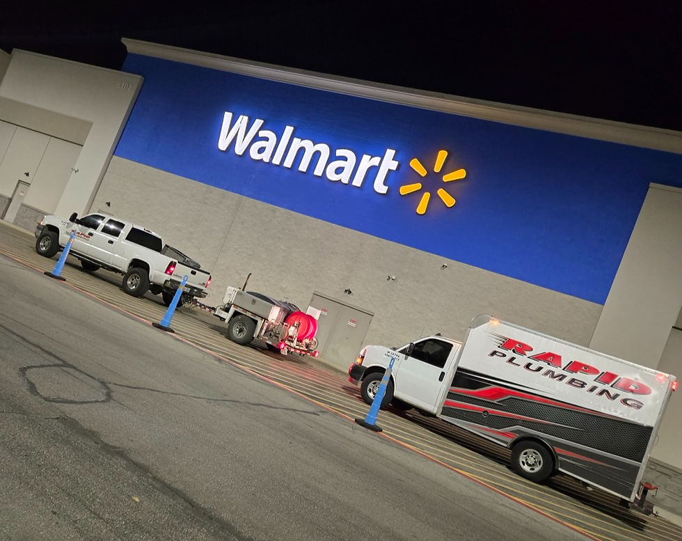 Rapid Plumbing trucks and hydro jetting equipment outside Walmart at night for commercial drain descaling service