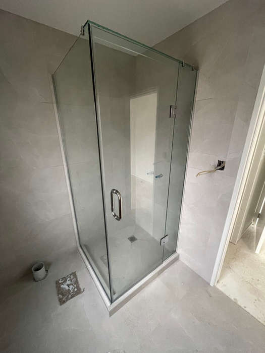 Custom corner glass shower enclosure installation with frameless design and chrome hardware in modern bathroom renovation - professional shower screen and glazing services