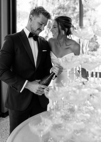 a bride and groom standing next to a champagne towe