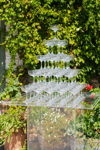 A champagne tower set up against a green wall