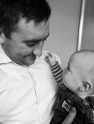 man with baby, chiropractor treating baby, baby looking at chiropractor, happy baby being treated
