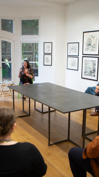 People viewing art in a gallery. Artwork from the Under Milk Wood exhibition. images Bonnie Helen Hawkins. Artwork displayed in a gallery setting.