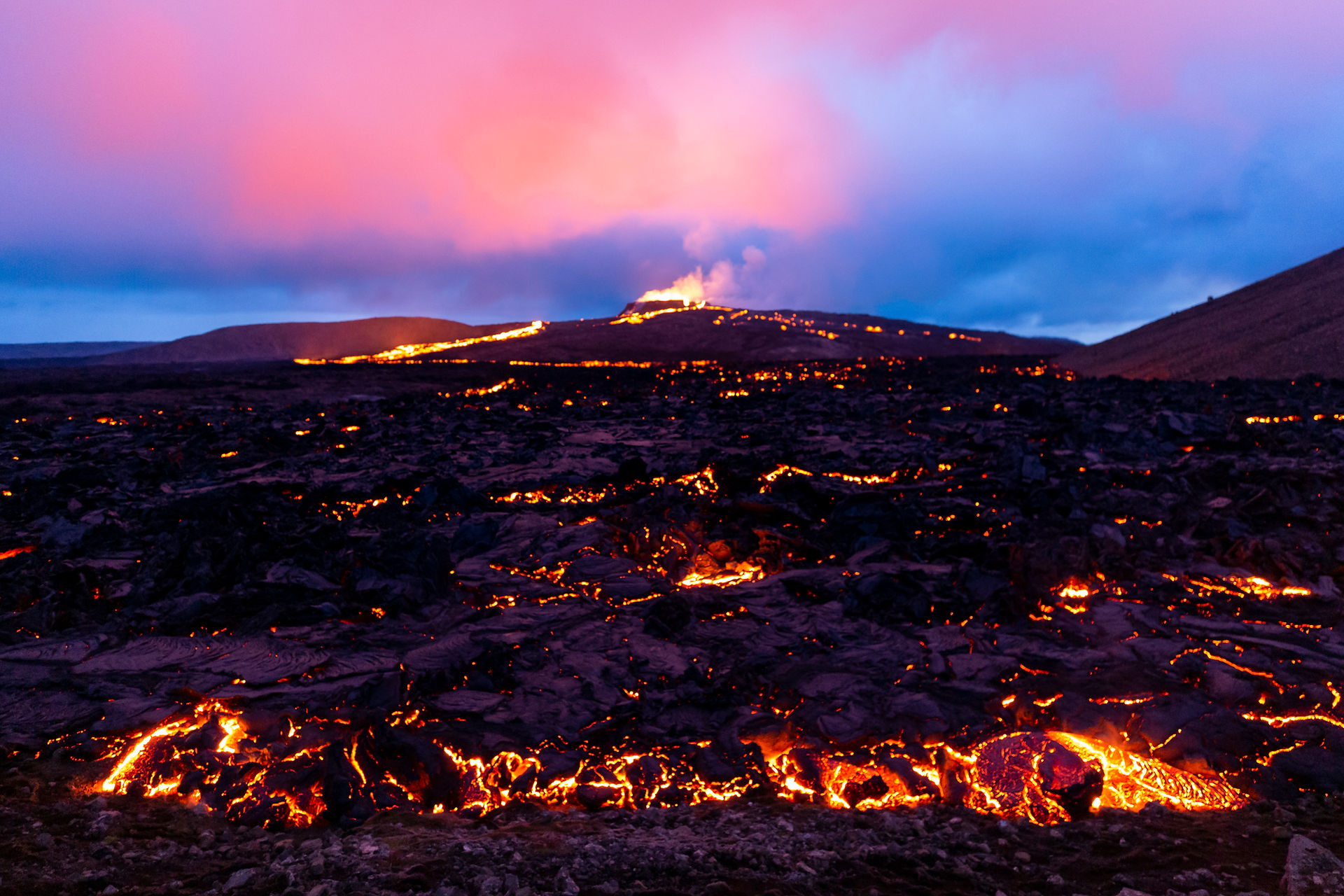 La lave devant nous avance doucement, le cratère au loin illumine le ciel