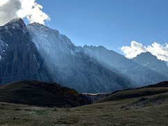 Un nuage passe devant le soleil qui se découpe en rais de lumière sur les montagnes, magnifique