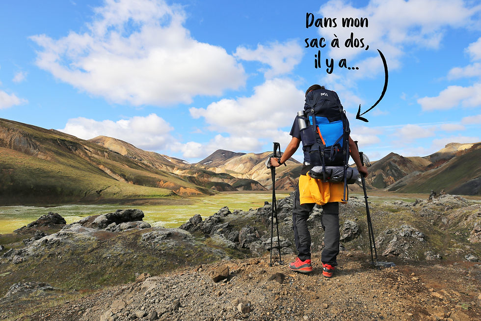 Un randonneur avec son gros sac à dos et ses bâtons de marche contemple le paysage de Landmannalaugar